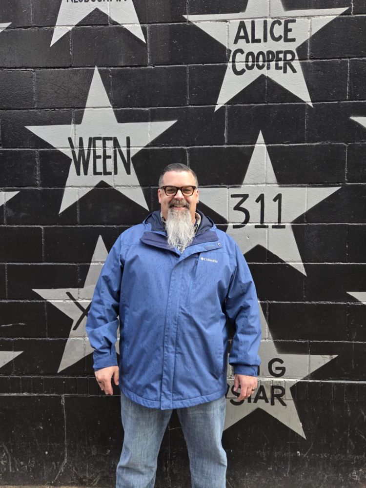 A photo of Nick, standing outside the stars on First Avenue Minneapolis's building.