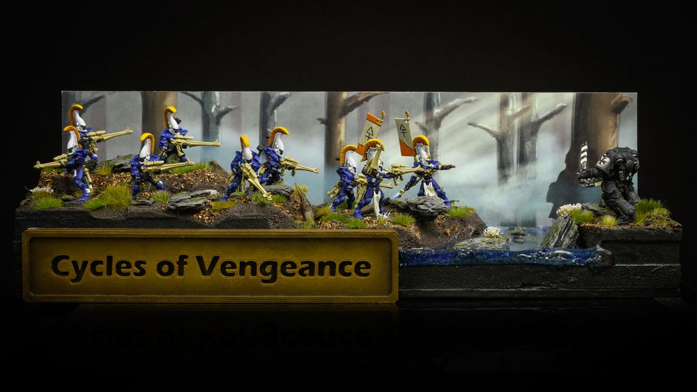 A picture of a miniatures display board featuring a woodland scene and painted backdrop with Dire Avenger miniatures facing off against Black Templar space marines. A river flows between them and a sign with the title "Cycles of Vengeance" in gold.