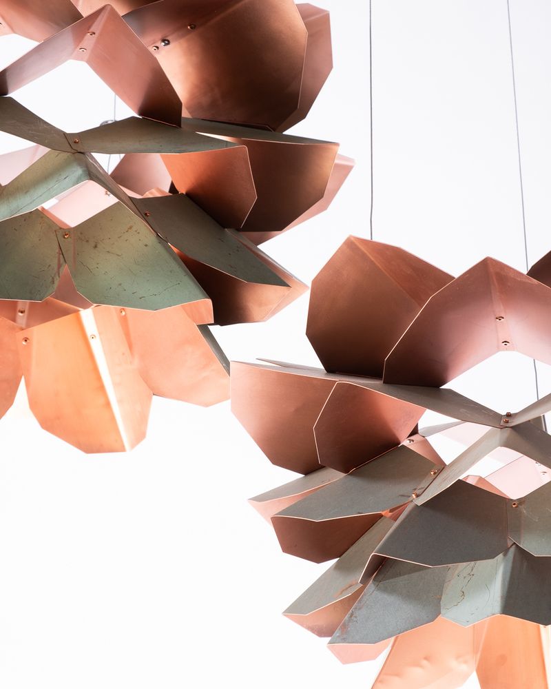 Detail showing two pendants and the contrast between the patinated top surfaces and bright copper undersides.