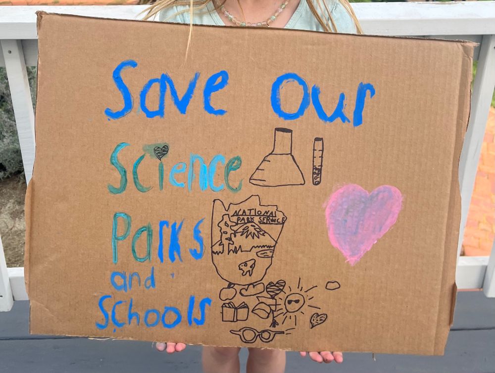 Protest sign made by a child that says “Save our science, parks and schools”