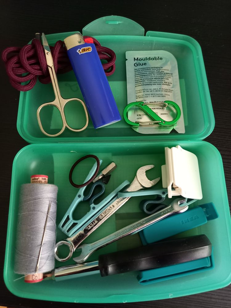 Inhalt der Dose: Feuerzeug, Karabiner, Schnur, Nagelschere, Schraubenzieher, Nadel, Faden, Wäscheklammern, Haargummi