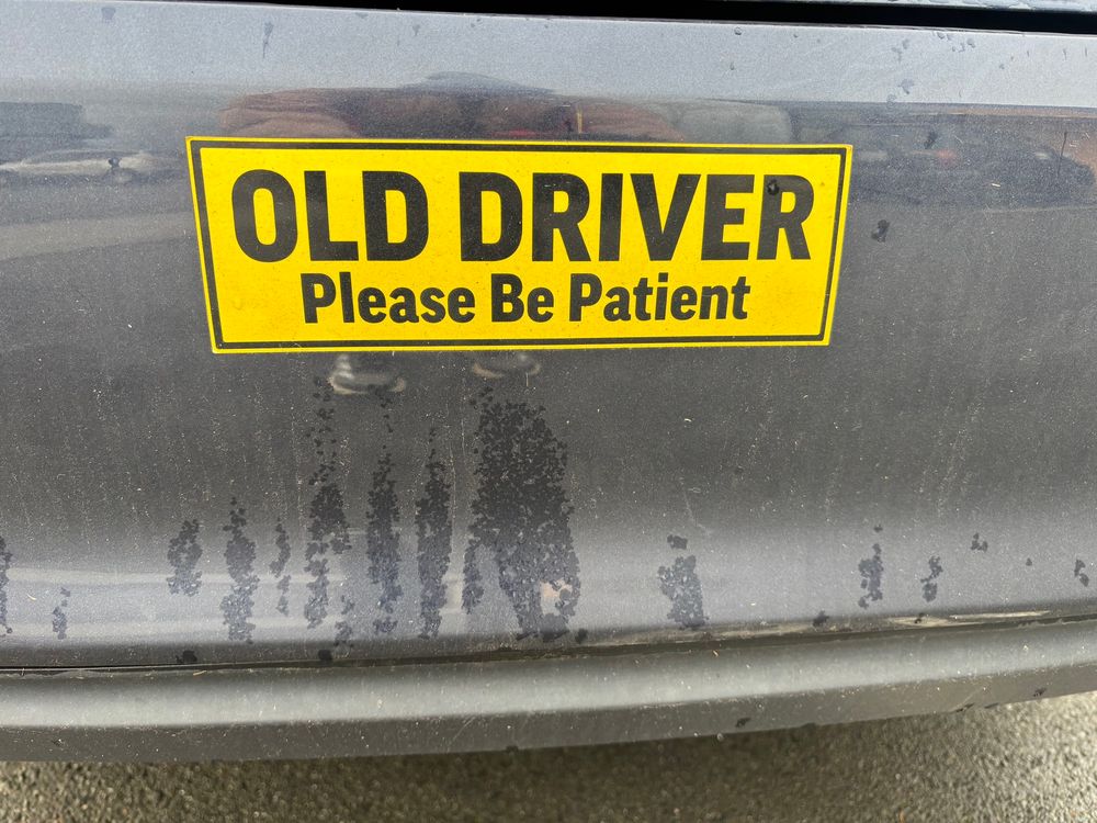 Bumper sticker that says old driver please be patient