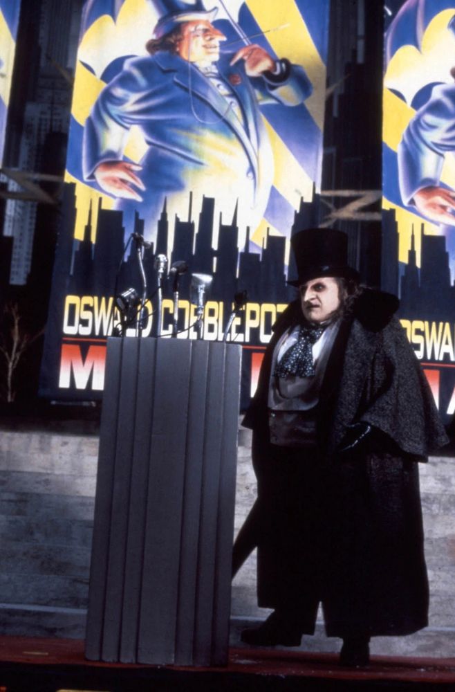 oswald cobblepot / the penguin (played by danny devito) in a mayoral campaign rally in gotham city in the movie batman returns
