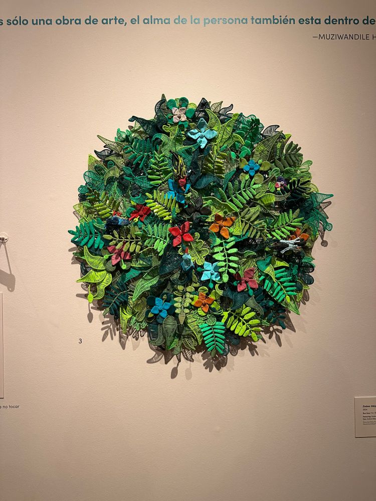 telephone wire art of a ton of leaves and flowers, looks like stumpwork (not sure if that's the right word, but the leaves are 3d and sticking out)