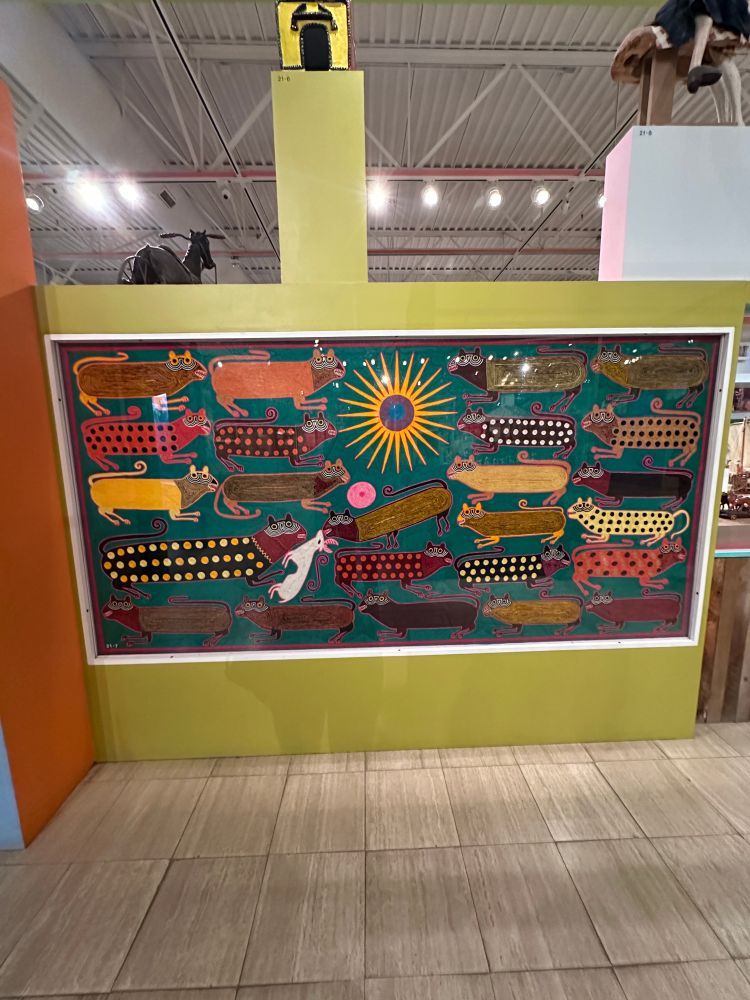 applique of a ton of brightly colored cats killing what looks like a goat