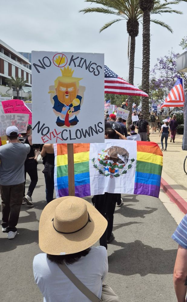 Protest sign of Trump as a clown sitting on toilet in San Diego “No Kings” protest