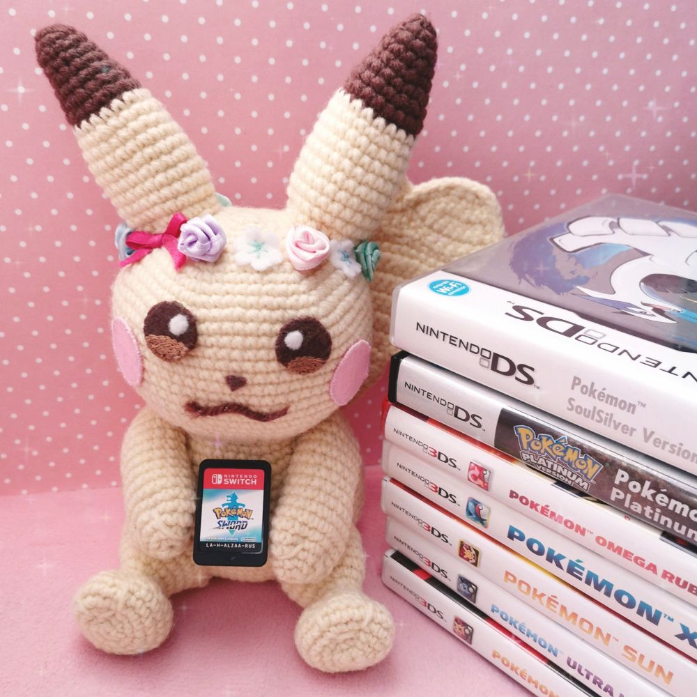 Pikachu amigurumi with my collection of Pokemon games 