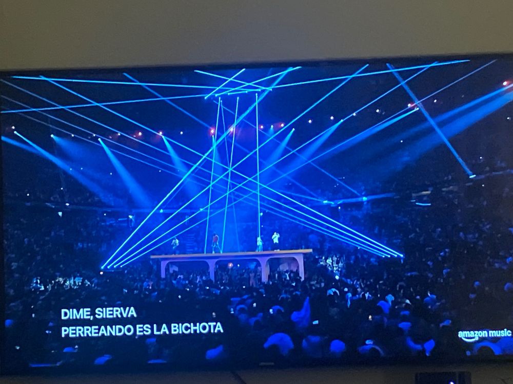 Four rappers on a house inside a stadium crowd