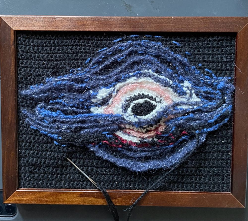 Schwarzes Loch aus verschiedenen  Wollen mit Nadel an schwarzen Faden, noch unfertig