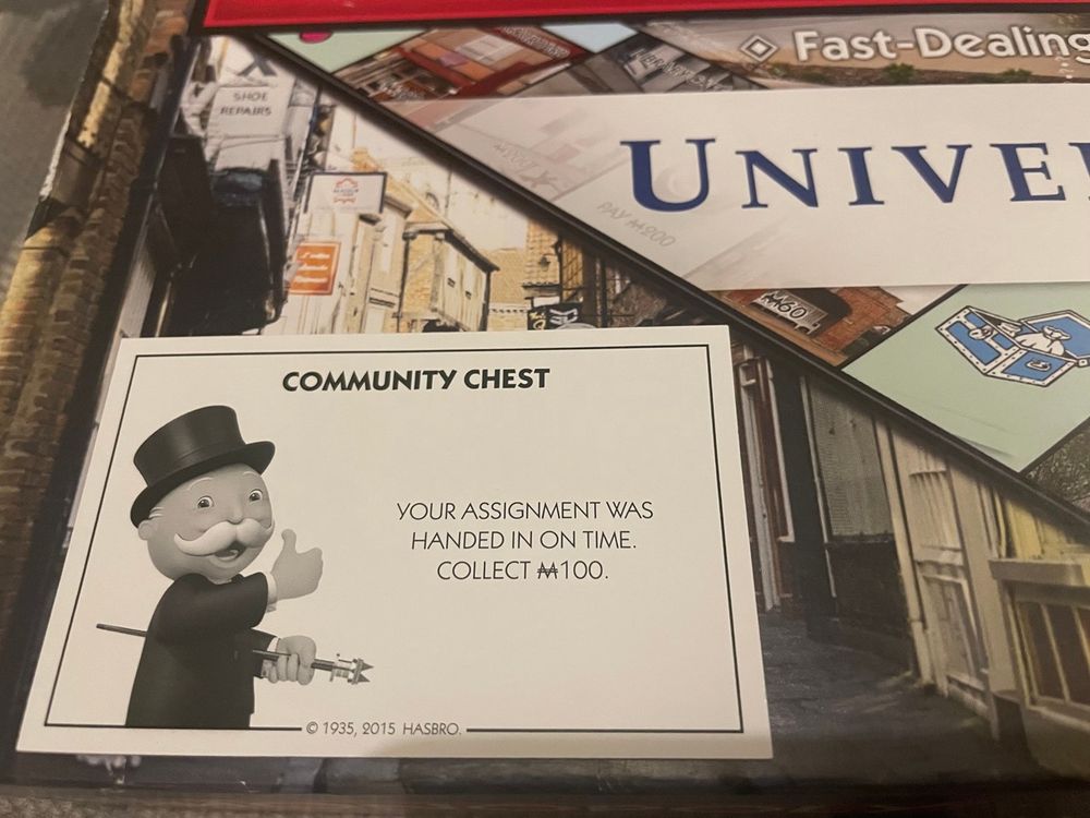 A 'Community Chest' card from the University of York version of Monopoly, reading 'Your assignment was handed in on time. Collect £100.'