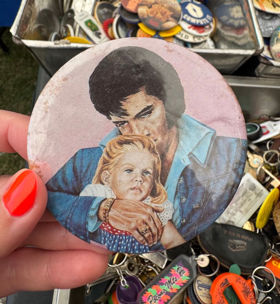 A button with artwork of Elvis Presley holding a little girl in a super creepy way, he’s smelling her head and she looks uncomfortable.  