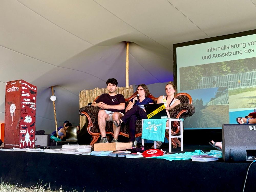 Kerem Schamberger und Valeria Hänsel von medico gemeinsam mit Julia Winkler von decriminalize gemeinsam auf der Bühne.