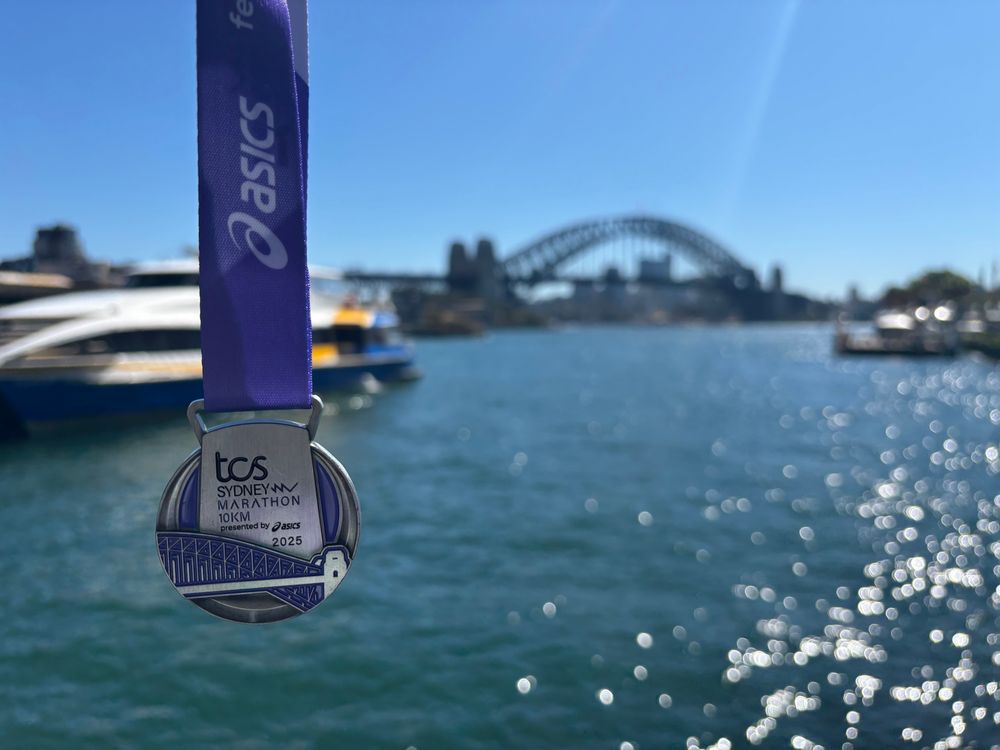 Sydney Marathon 10km medal, with Sydney Harbour Bridge as the background