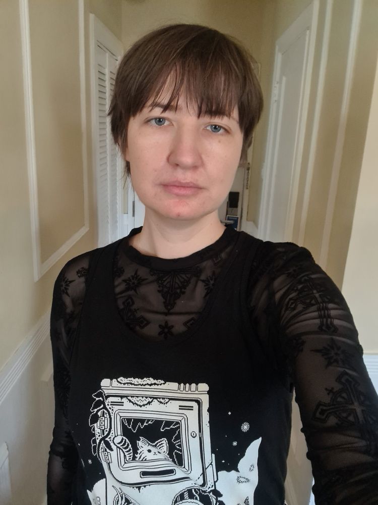 Selfie of me wearing a black top in what looks like the back rooms