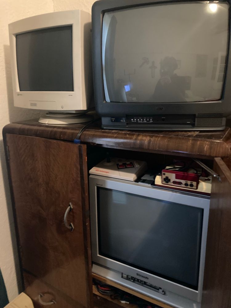 3 more CRTs on and in a big wooden cabinet next to the monitors on the floor