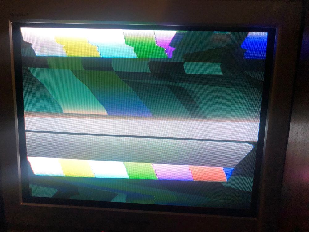 photo of my 90s Panasonic CRT TV displaying two video sources over the top of each other - a set of colour bars and a white screen