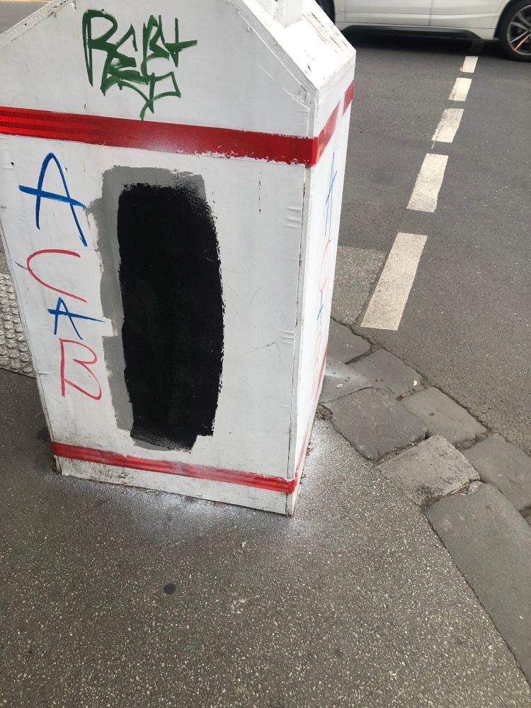 ACAB graffiti that has been painted over multiple times