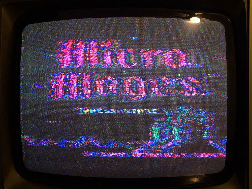 Photo of my 80s CRT TV not syncing properly to the NES’s signal. Micro Mages is covered in static and has a huge amount of colour fringing.