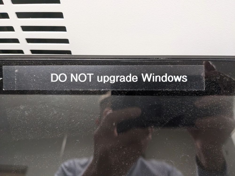 photo (from October 17, 2023) of a computer screen with a label printed on it, which reads: "DO NOT upgrade Windows"