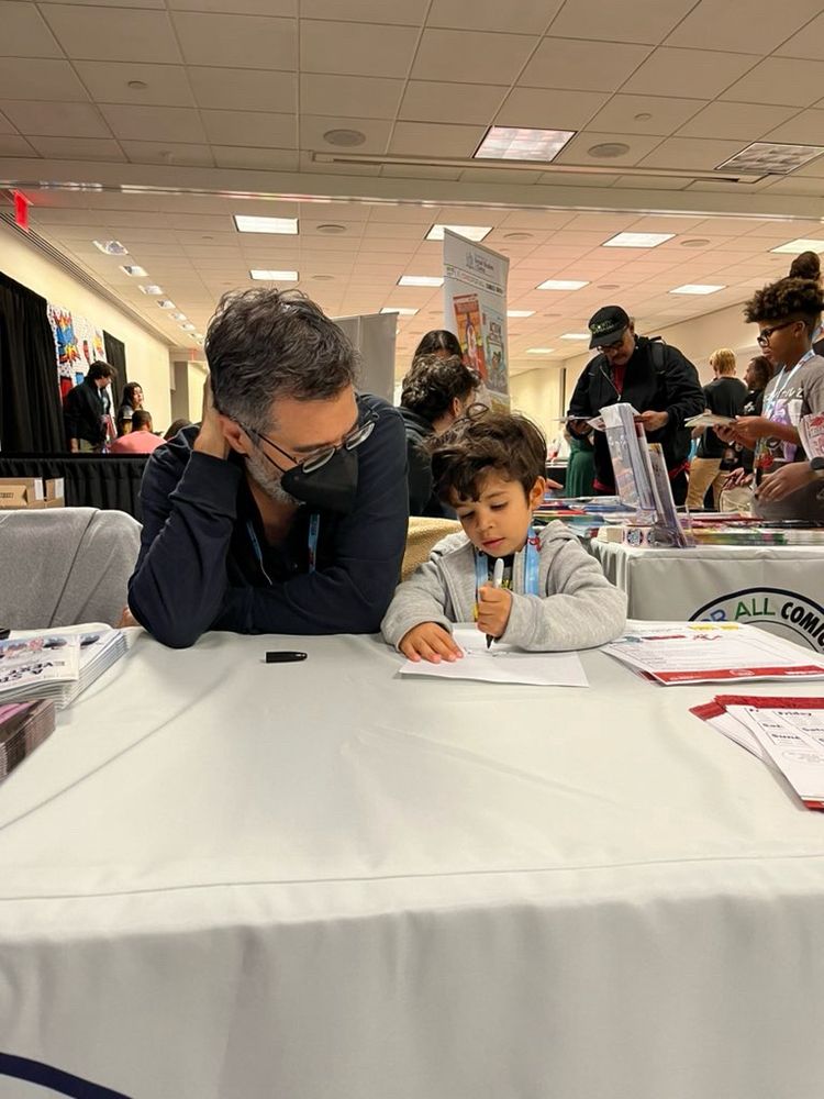 Comic Book Writer and Film Director, Greg Pak, at the Comics for All Civics Group booth with a student at New York Comic Con 2024.