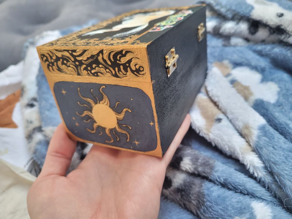 Side of the box featuring an ornamental medieval looking sun