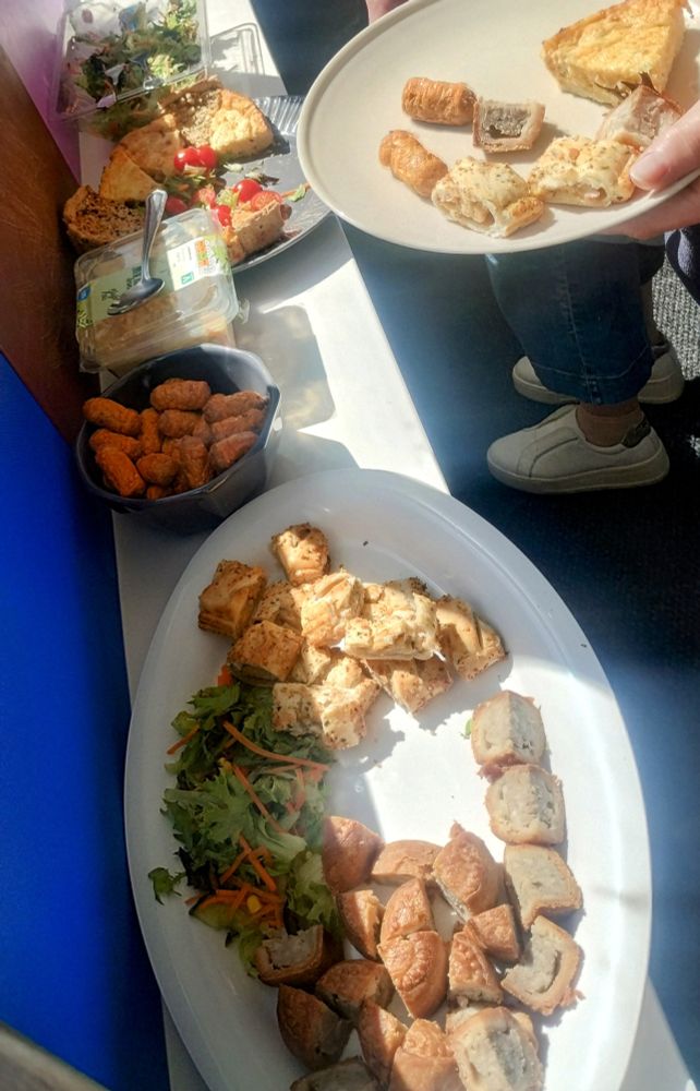 Sliced mini pork pies, cheese and onion rolls, coleslaw, quiche, salad and tiny sausages.
