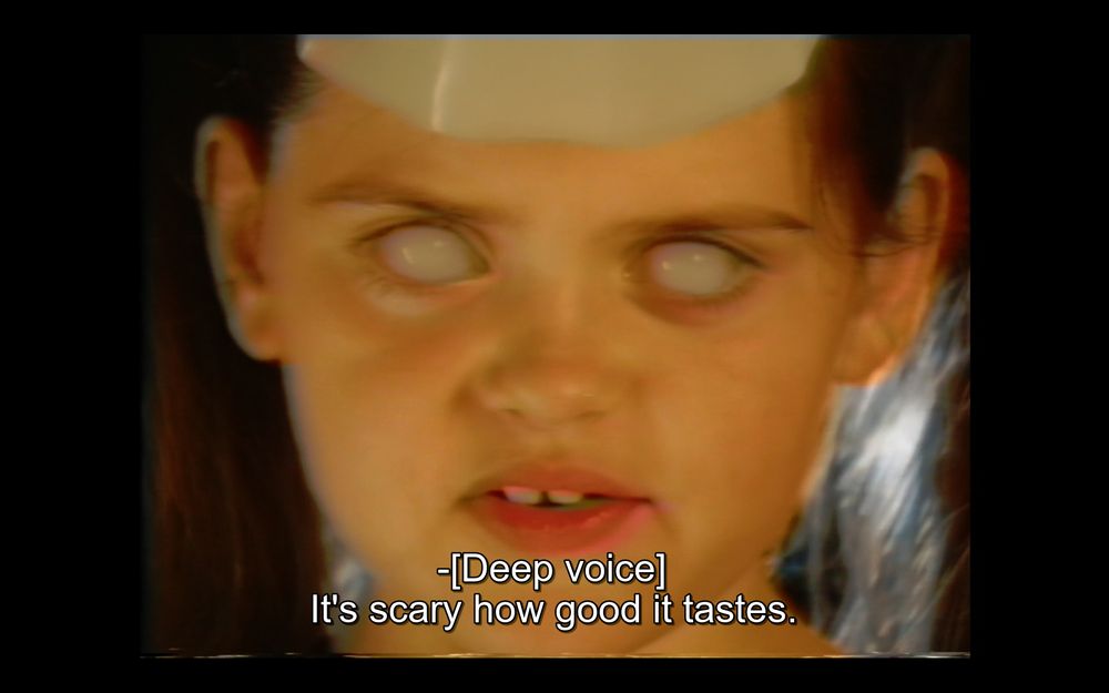 Screen capture from the film V/H/S/Halloween (2025). A possessed little girl drinks Diet Phantasm and comments (in demonic voice): "It's scary how good it tastes."
