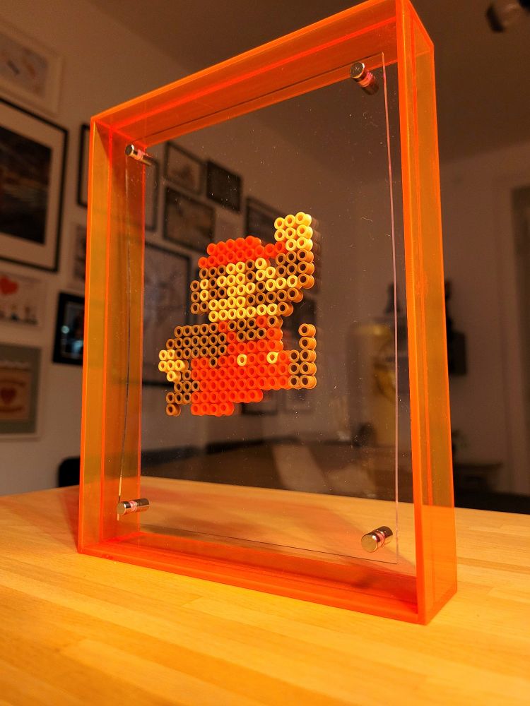 Pixel art sprite of Super Mario by @caveofpixels, suspended in a frame