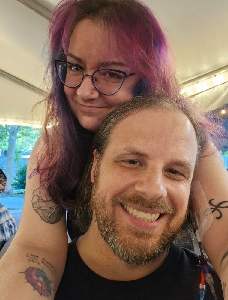 Middle-aged white couple smiling at the camera before a concert