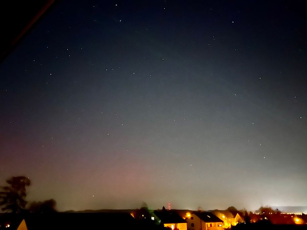 Ein Foto eines Nachthimmels mit leichten roten Flecken. 