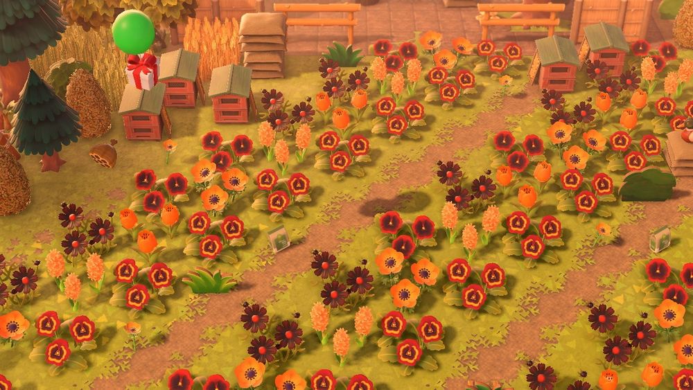 In Animal Crossing: New Horizons, a ballon present floats through a warm-toned flower meadow of pansies, wildflowers, hyacinths, tulips, and cosmos. 
