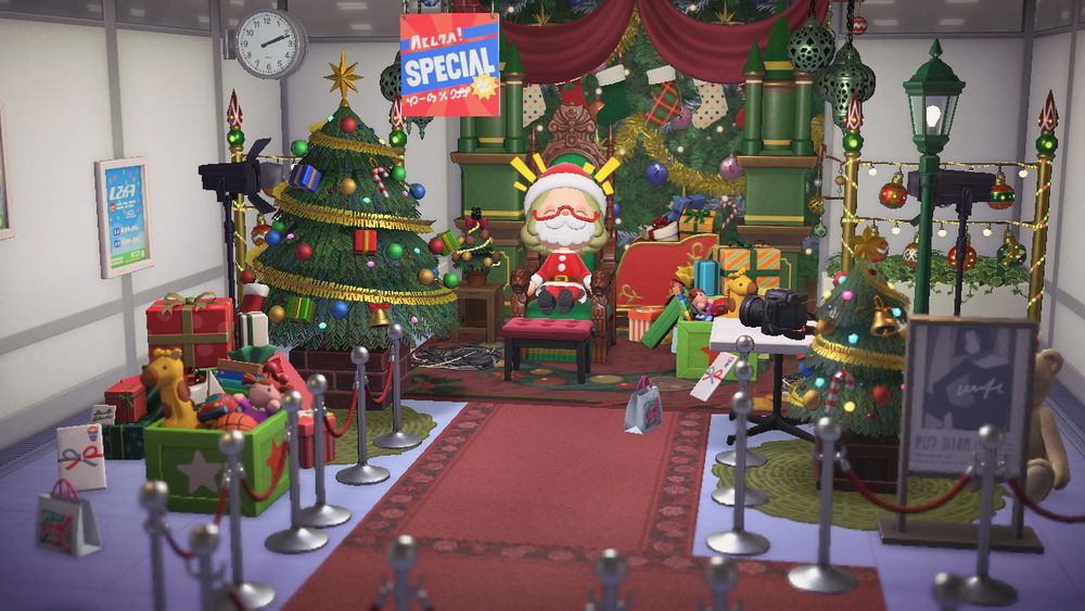 In Animal Crossing: New Horizons, a classic mall display for taking photos with Santa, surrounded by lights, trees, and gifts. A player dressed as Saint Nick sits joyfully on her chair. 