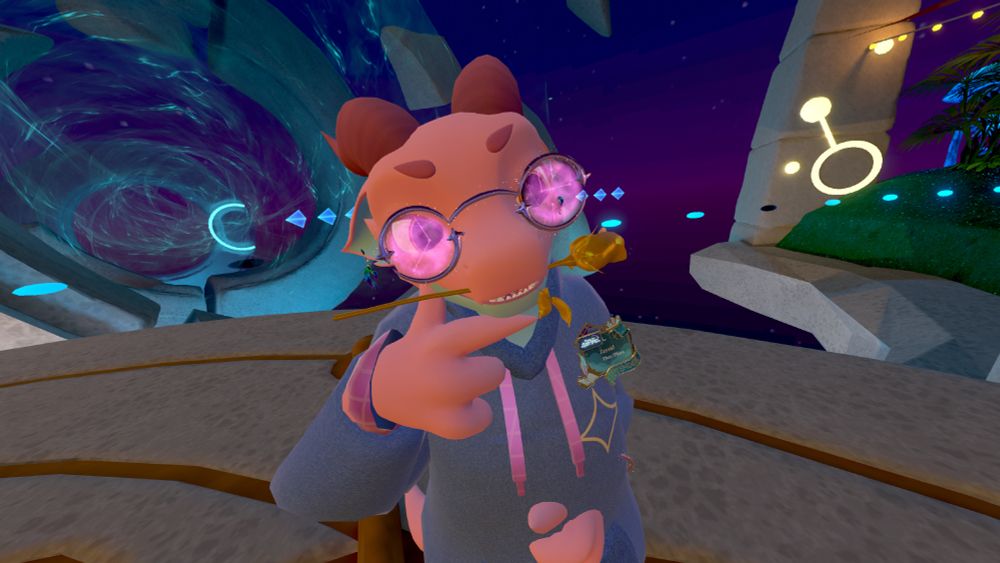 Screenshot of VRChat where Zayzid's Furality Somna avatar is looking smugly at the camera with a golden rose in their mouth. They are wearing a blue hoodie with golden sigils, golden glasses and rainbow earrings, and purple constellation-patterned shorts