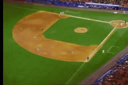 GIF quickly moving around a baseball from above with the players running and audience members in the stands. 
