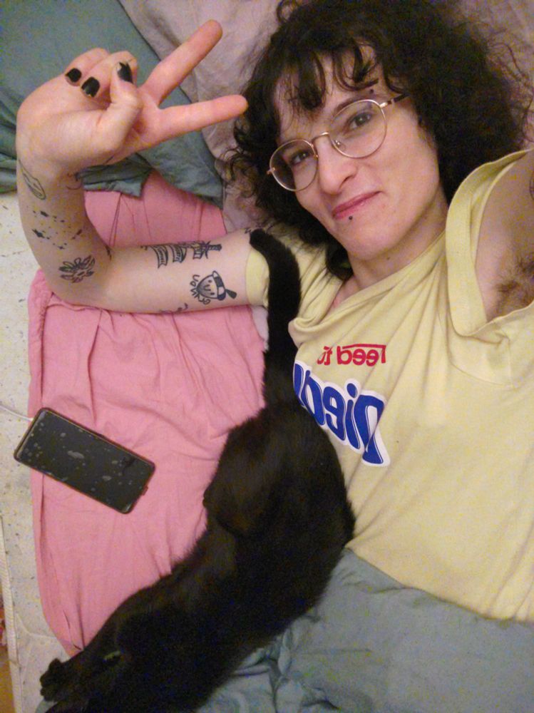 Zélie, en pyjama avec un chat noir contre lui