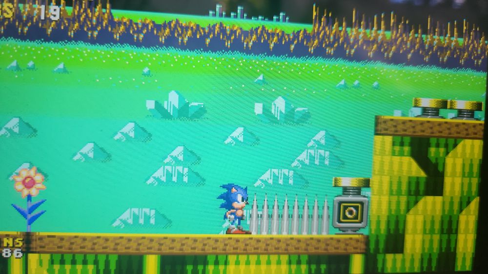 An off cam picture of Sonic Origins' Sonic CD being played on a Steamdeck. Against a row of spikes, a ring monitor is present which is also blocked by a yellow spring placed right over said ring monitor.
