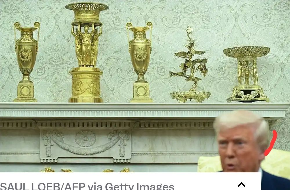 White House mantelpiece loaded down with dumbfoundingly cheesy fake gold knickknacks, possibly plastic. Ignore floating head at bottom.