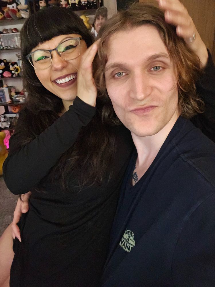 Two people sitting in chair making silly face and smiling 