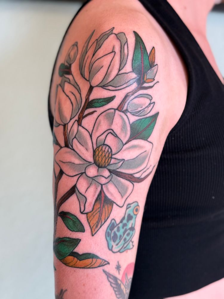 Magnolia tattoo half sleeve on a white persons arm