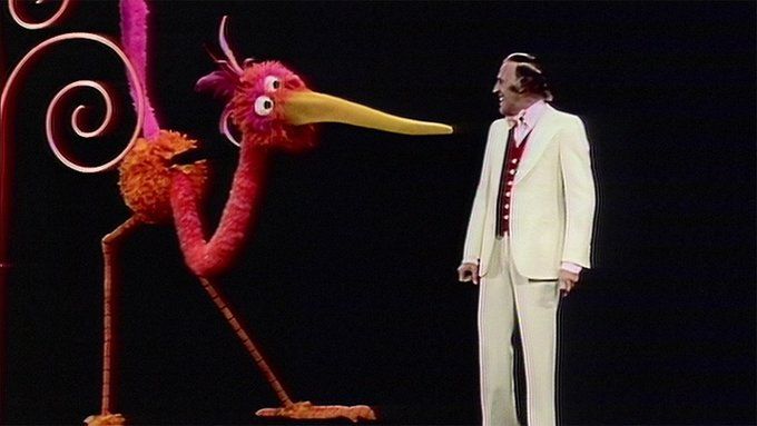 Bruce Forsyth on the Muppet Show looking at a Gawky Bird, a thin ostrich type bird with a long nose which is looking at him while he performs a musical number