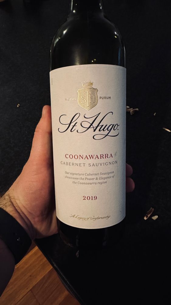 A hand holding a bottle of St Hugo Coonawarra Cabernet Sauvignon, 2019 vintage.