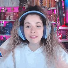 a woman with curly hair wearing headphones and a white hoodie with the word press on it