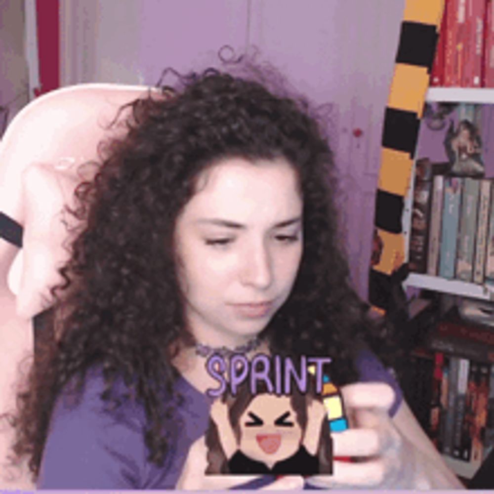 a woman with curly hair is holding a stuffed animal with the word sprint on it