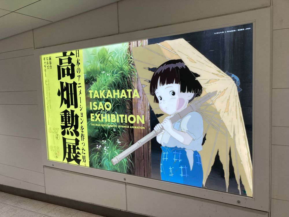 高畑勲展の壁広告。火垂るの墓の節子が破れ傘をさすシーンのイラスト