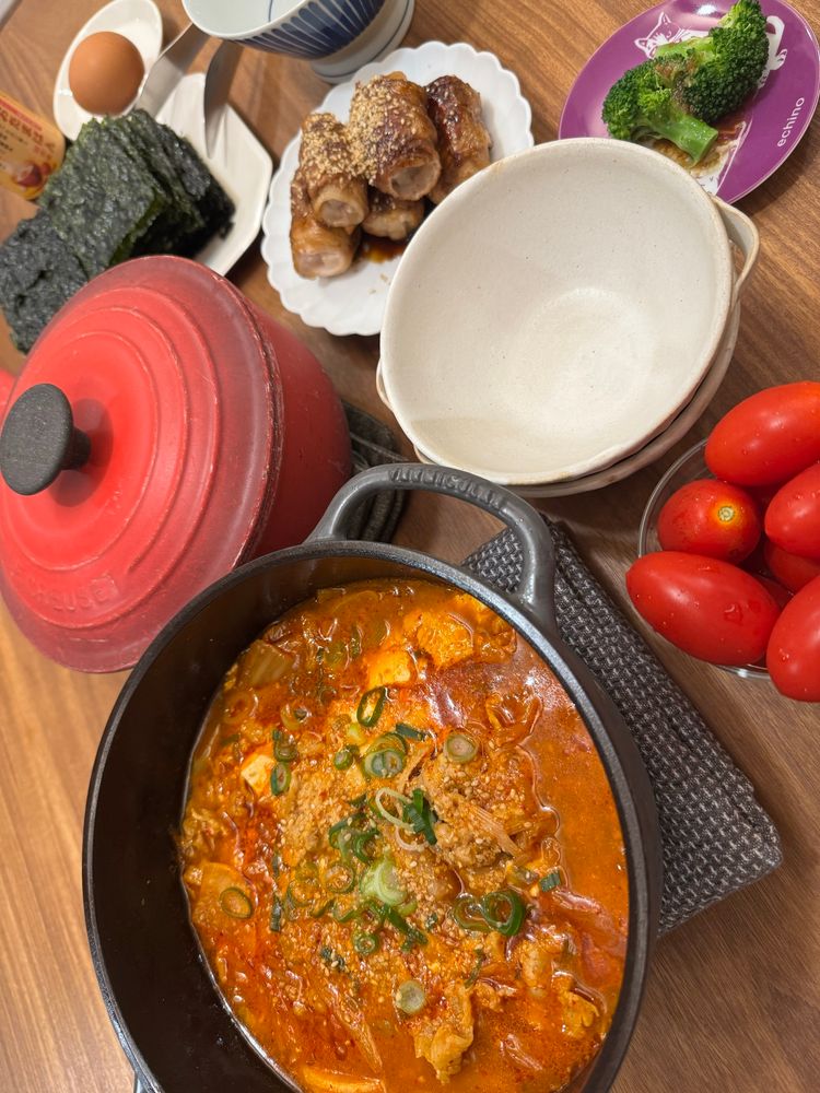 キムチチゲ、大根の肉巻き、ミニトマト、ブロッコリー、韓国海苔、生卵、ご飯