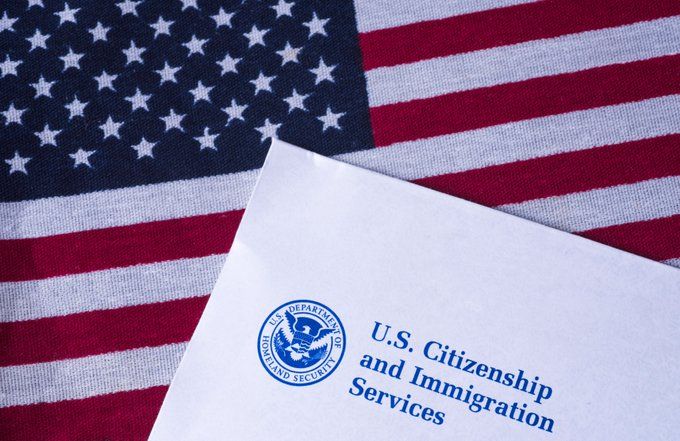 An American flag and a folder with U.S. Citizenship and Immigration Services on the front.