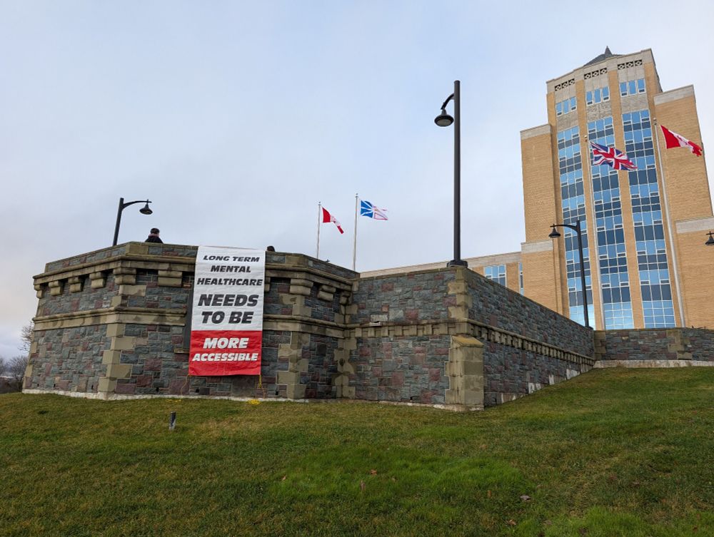 A sign over the wall at confed that says long term mental healthcare needs to be more accessible.