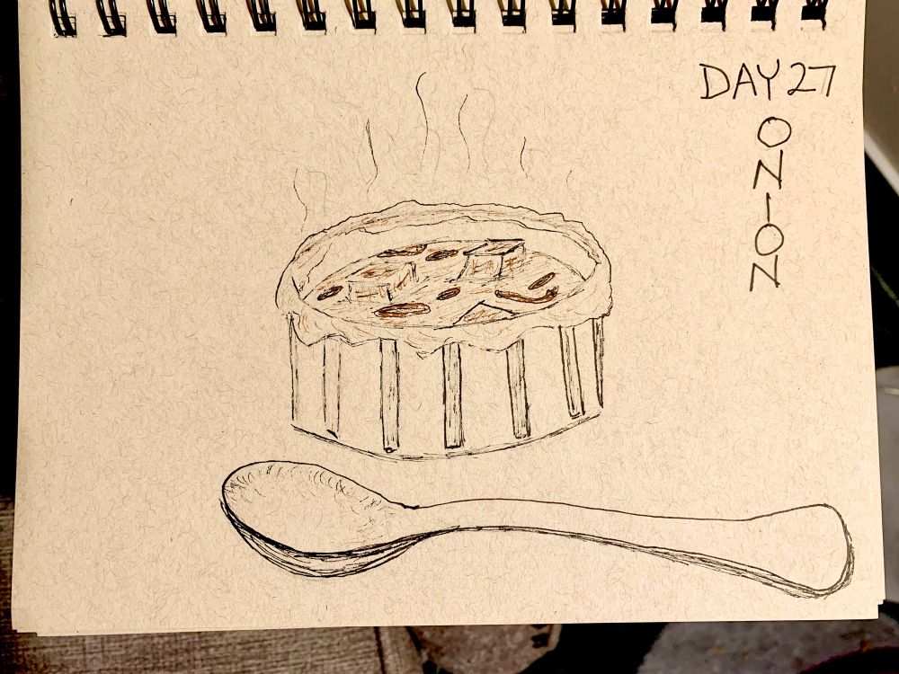 A ramekin of French Onion Soup with crusted cheese baked on the edges with croutons floating in the soup and a large soup spoon laying in front of the ramekin.  