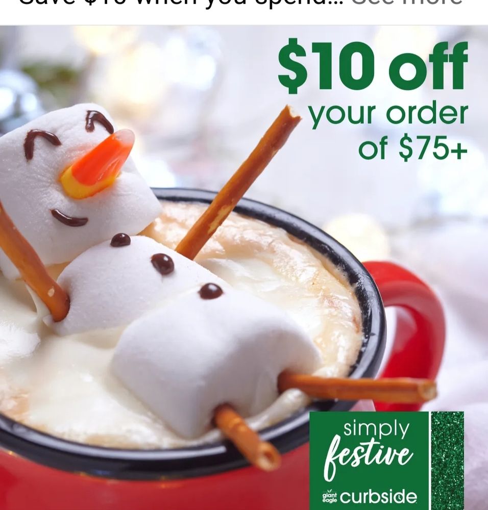 Mug of hot chocolate topped with marshmallow snowman with pretzel stick legs and a candy corn nose.