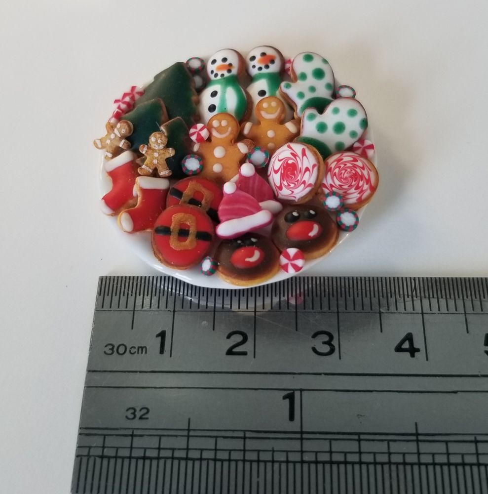 Cookie tray magnet with sugar cookies: stockings, Santa belly,  Rudolph, hats, mittens, trees, snowmen and gingerbread men with Christmas mints.  A silver ruler shows the size on cm and inches.